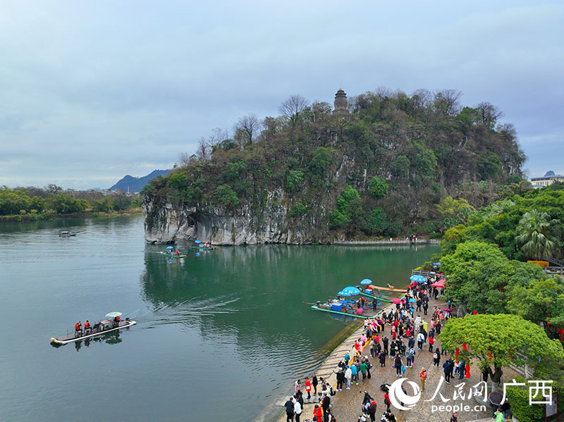 人們乘坐竹排，在漓江上欣賞象鼻山美景。人民網(wǎng) 付華周攝