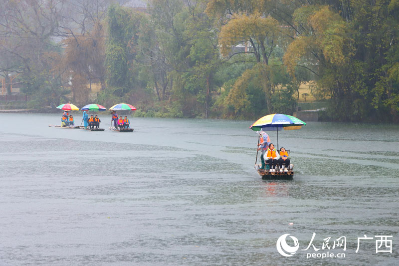 人們雨中乘坐竹筏欣賞遇龍河美景。人民網(wǎng) 付華周攝