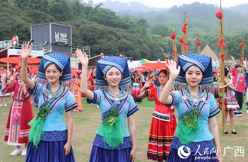 身穿民族服飾的女孩在揮手致意。人民網(wǎng)記者 彭遠(yuǎn)賀攝