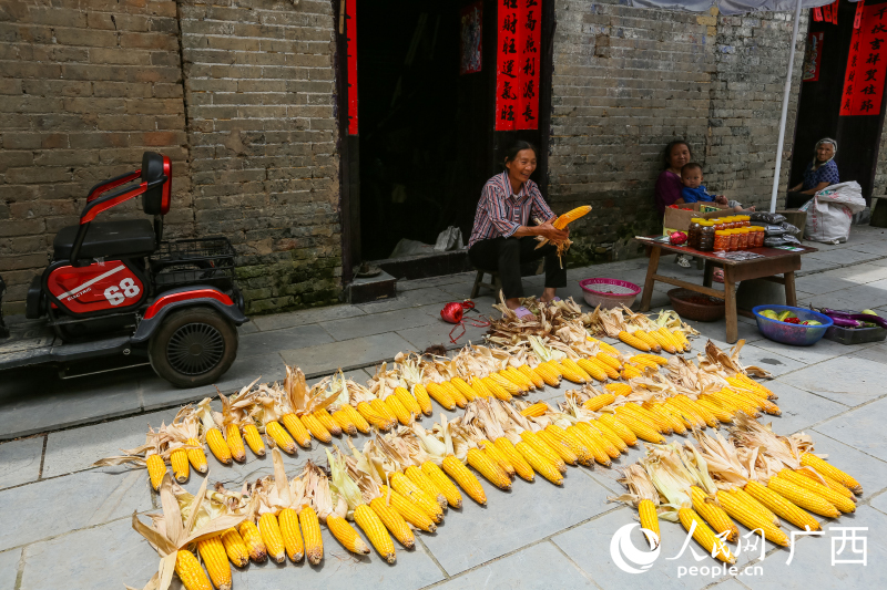 村民在家門口晾曬玉米和銷售土特產(chǎn)。人民網(wǎng) 何寧攝