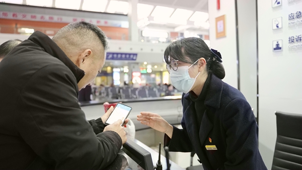 張婷婷在為旅客解答車(chē)票咨詢問(wèn)題。李俊鳴攝