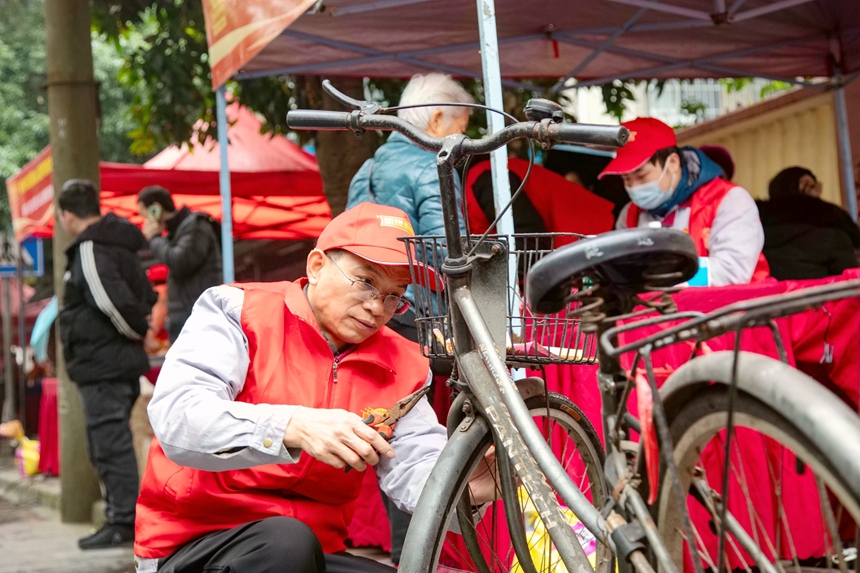 圖為志愿者為市民維修自行車。蔣少闐攝