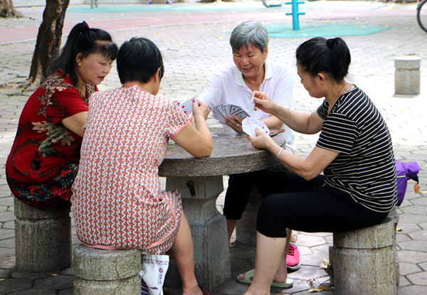 社區(qū)居民坐在石椅上打著撲克。張泳鴻攝