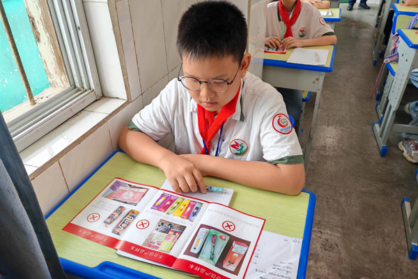 小學生正在學習《無煙校園》宣傳冊內容。姚曉攝