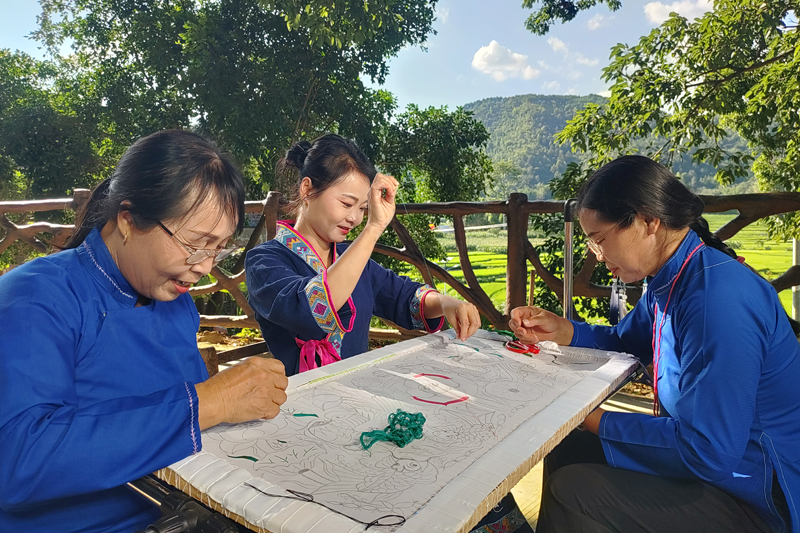 七里刺繡非遺傳承人凌漫麗（中）在朔晚村巴查屯大榕樹(shù)下教授技藝。