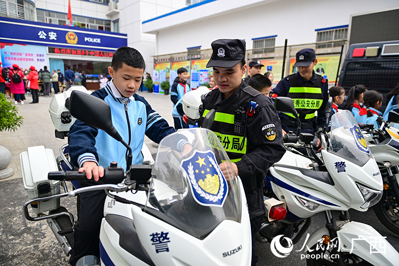 警務(wù)人員在給小朋友介紹警用摩托車。人民網(wǎng) 雷琦竣攝