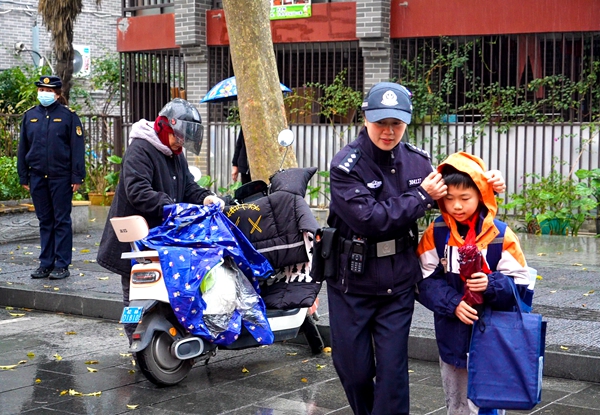 民警護(hù)送學(xué)生過馬路。